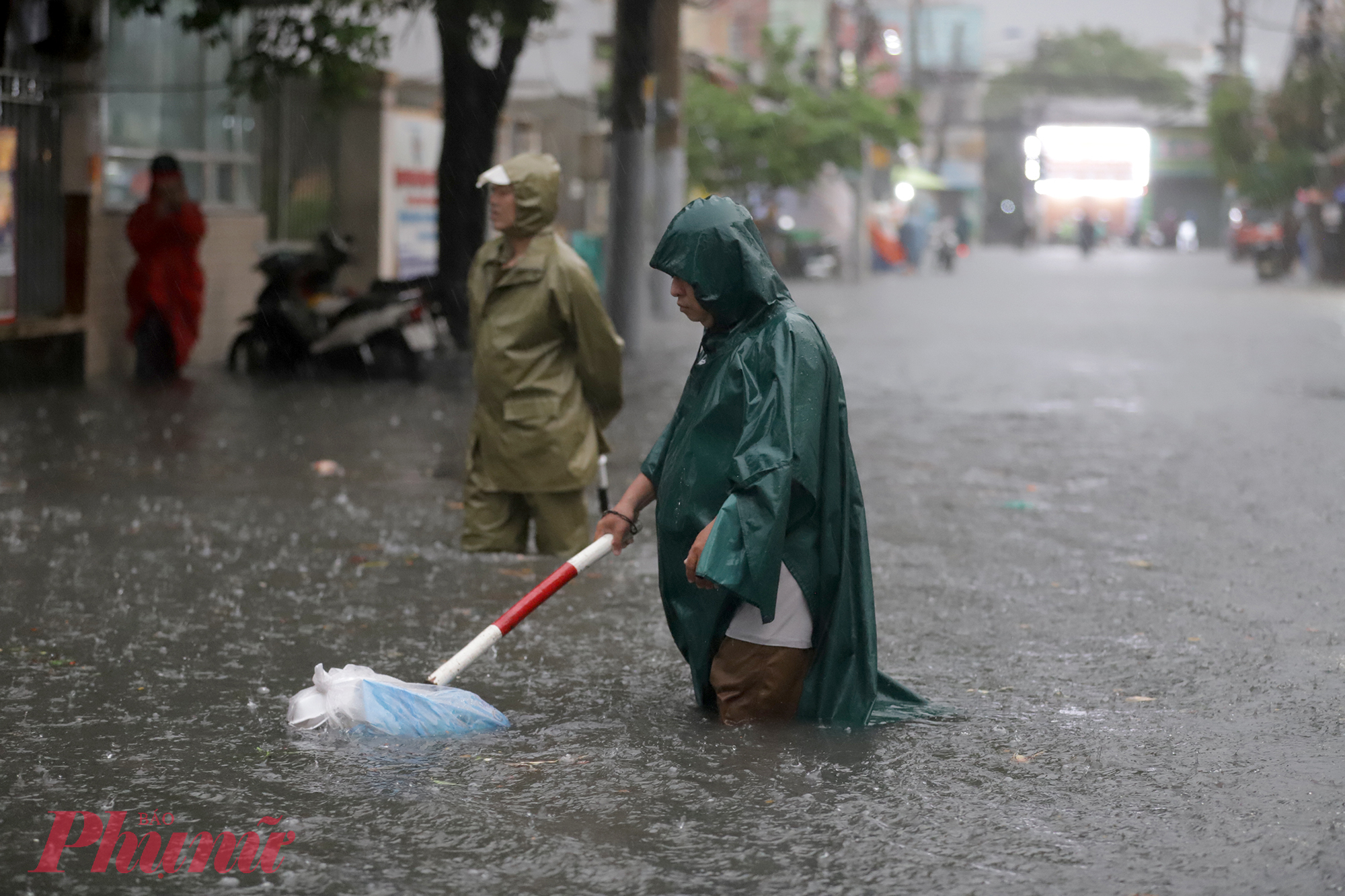 Một số cán bộ phường được huy động để túc trực, hướng dẫn người dân đường đi để tránh đi vào chỗ ngập nặng.