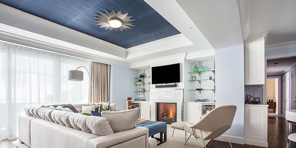 Một mảng giấy dán tường màu xanh trên trần nhà tạo thêm điểm nhấn màu sắc cho căn phòng tuyệt vời đầy phong cách này của McBrien Interiors .
