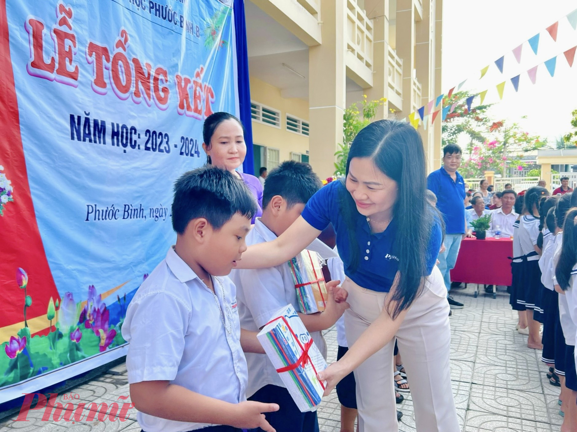 Bà Phạm Thị Vân Anh trao tập và động viên các em học sinh cố gắng học tập tốt trong thời gian tới.