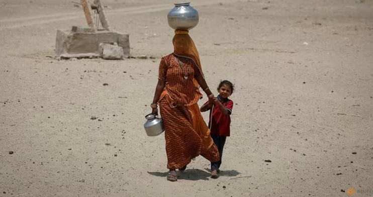 Một người phụ nữ đi bộ về nhà sau khi múc nước từ một cái giếng cạn ở khu vực sa mạc vào một ngày hè nóng nực ở Barmer, Rajasthan, Ấn Độ, ngày 26 tháng 4 năm 2024. (Ảnh chụp: REUTERS/Adnan Abidi)