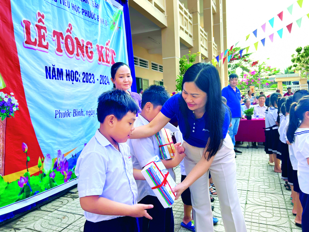 Bà Phạm Thị Vân Anh - Phó tổng biên tập Báo Phụ nữ TPHCM - tặng sách vở và khen ngợi các em học sinh có thành tích tốt trong năm học 2023-2024