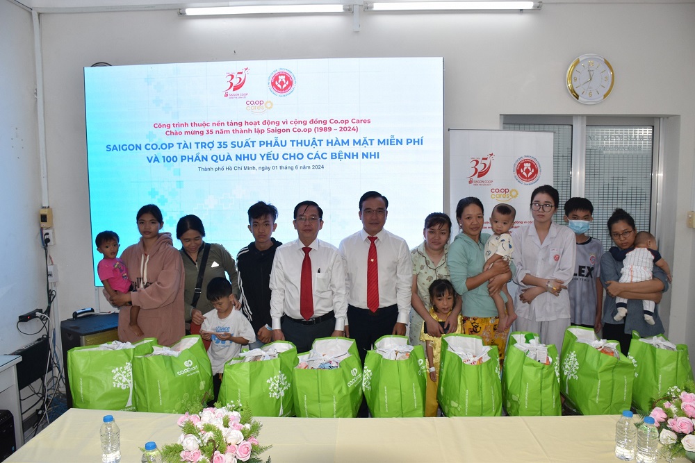 Ông Nguyễn Ngọc Thắng - Giám đốc Khối vận hành hoạt động Co.opmart - trao tặng và đại diện Bệnh viện Răng Hàm Mặt TPHCM trao tặng phần quà nhu yếu cho các bệnh nhi - Ảnh: Saigon Co.op