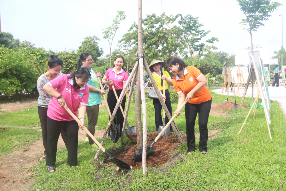 Bà Trần Thị Phương Hoa (bìa phải)– Phó chủ tịch Hội LHPN TPHCM –  cùng chị em ở TP Thủ Đức trồng cây hủ xanh, tạo bóng mát trong công viên Phạm Đôn Lễ.