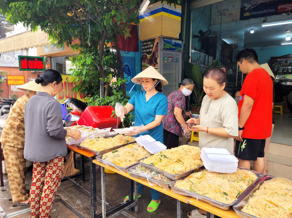 Dù bận rộn, 16 năm qua, bác sĩ Lê Thanh Nga (áo xanh) vẫn duy trì bếp ăn cho người nghèo