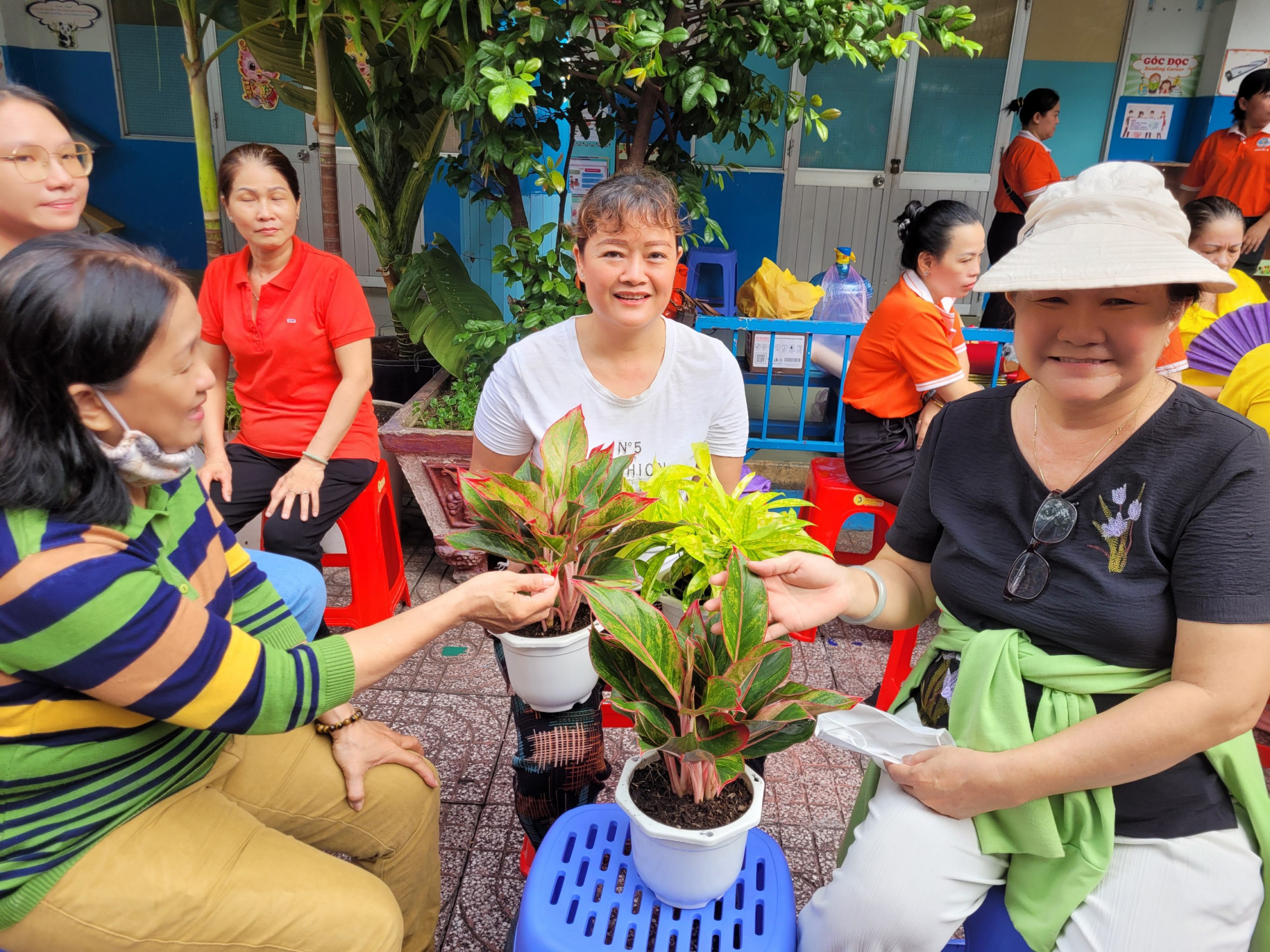 Các hộ gia đình hội viên, phụ nữ vui vẻ nhận lấy cây xanh từ chương trình