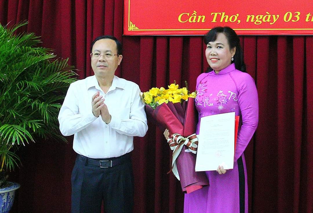 Ông Nguyễn Văn Hiếu - Bí thư Thành ủy Cần Thơ (áo trắng bên trái) trao quyết định và tặng hoa chúc mừng bà Võ Kim Thoa