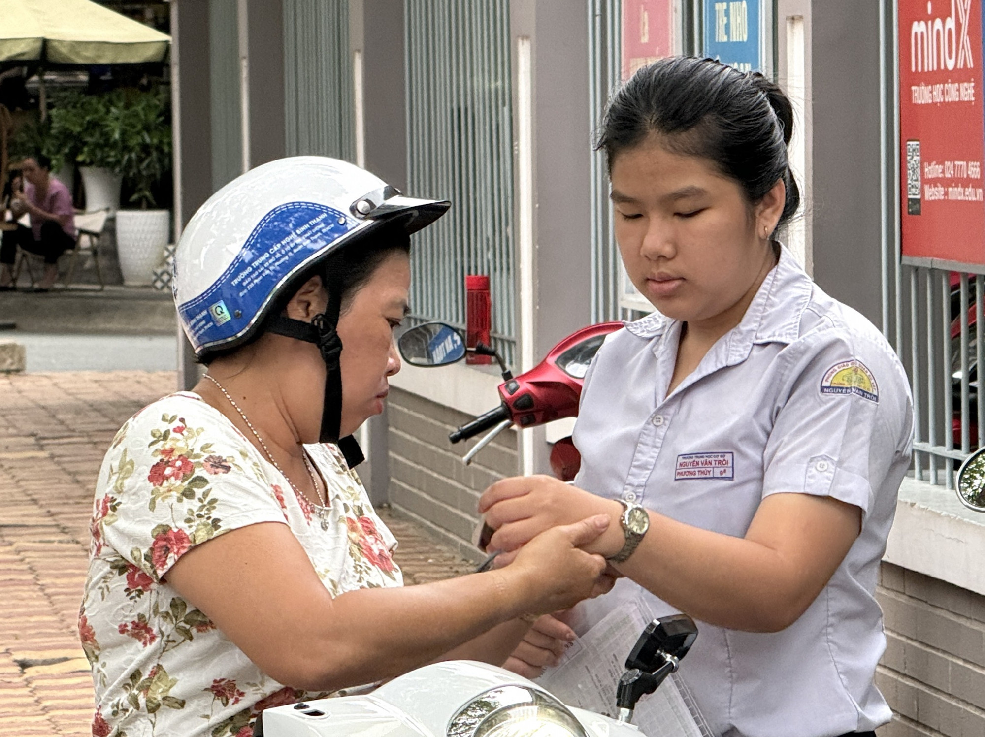 Còn tại điểm thi Trường THCS Phan Văn Trị (quận Gò Vấp) phụ huynh cũng chở con tới sớm, đeo đồng hồ và nhắc nhở con chia giờ để làm bài phù hợp