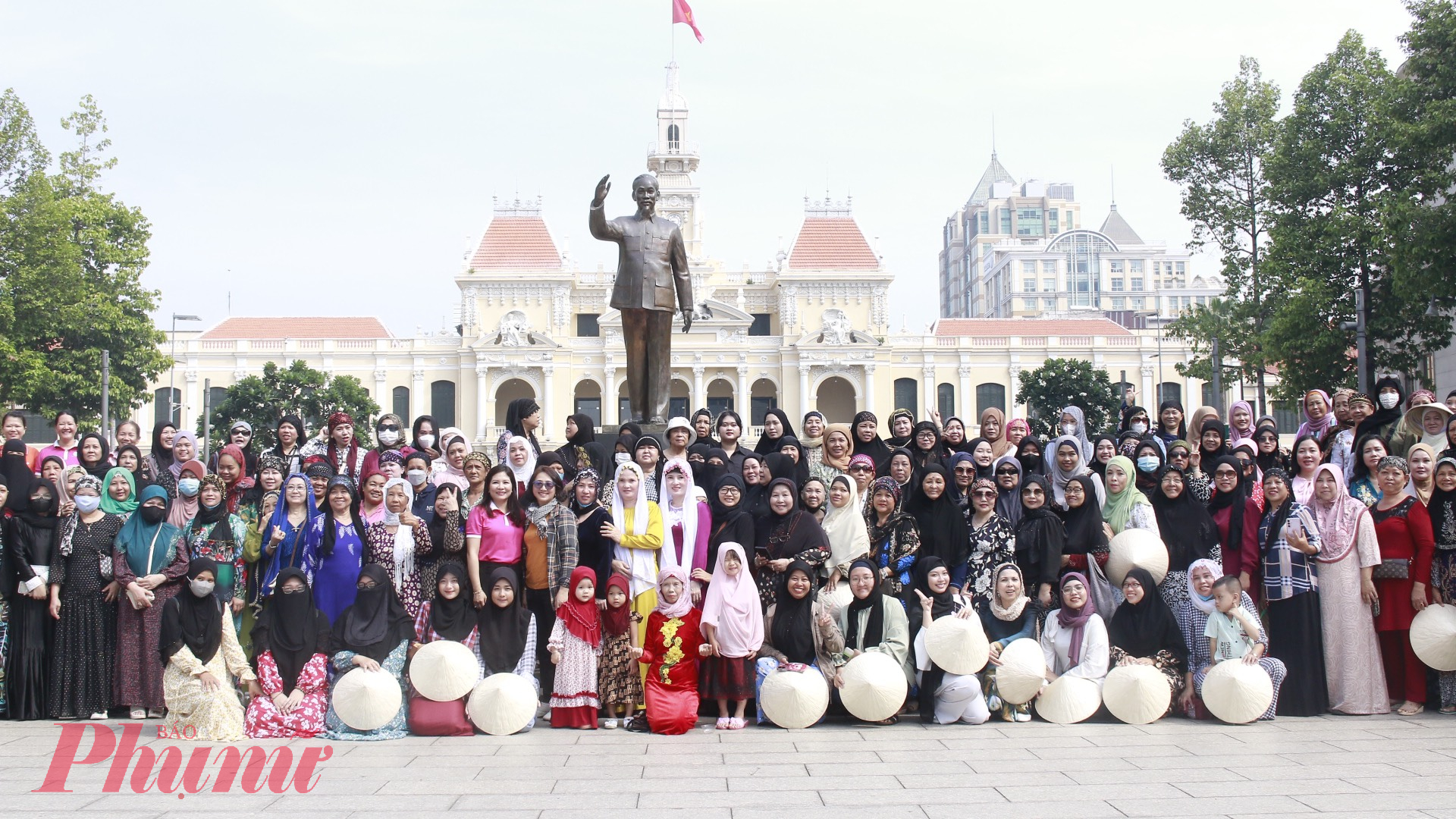 Hội viên phụ nữ Chăm chụp ảnh lưu niệm tại tượng đài Chủ tịch Hồ Chí Minh trên phố đi bộ Nguyễn Huệ