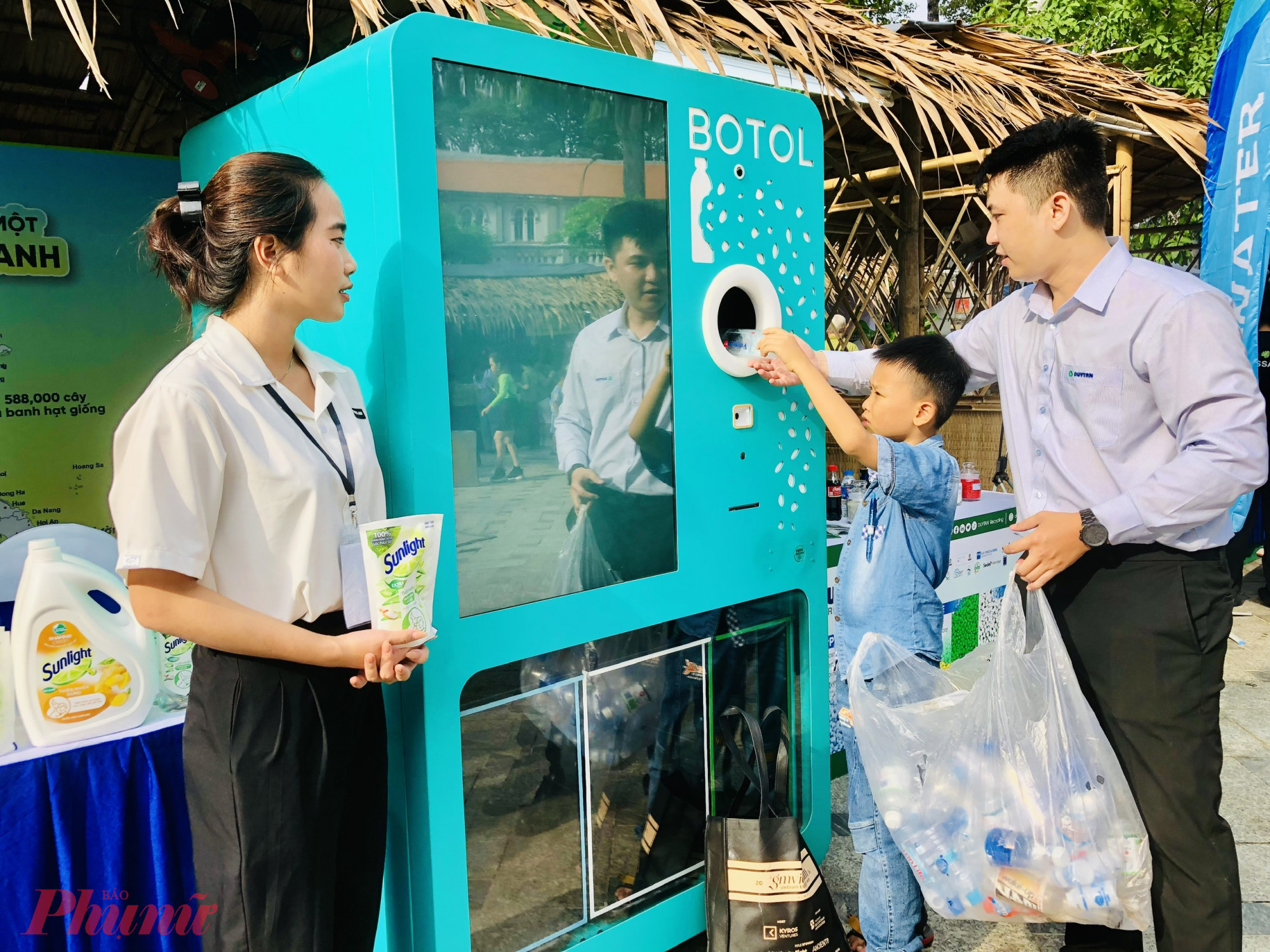 Các em nhỏ đang đưa chai nhựa vào máy 