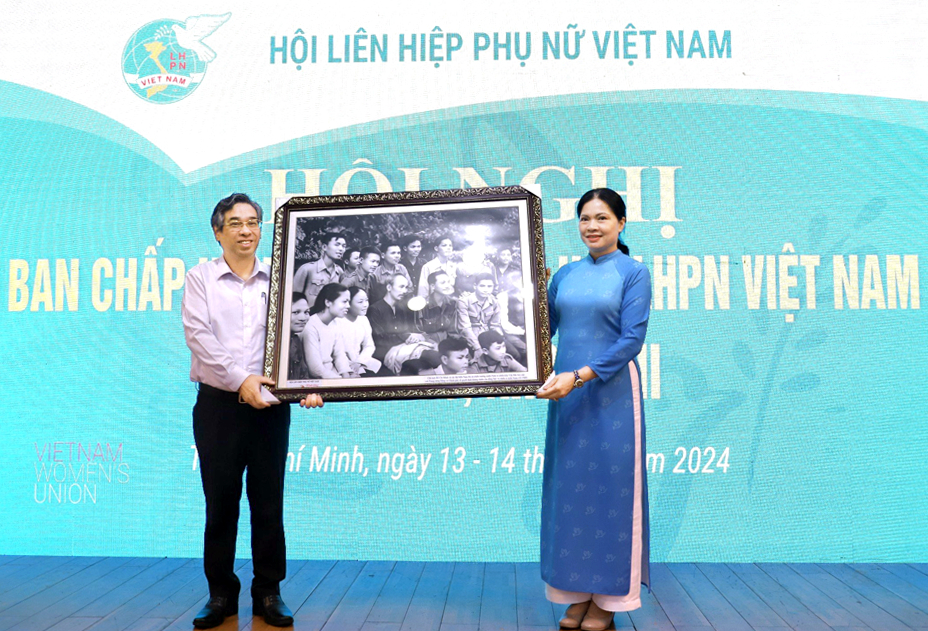 Phó bí thư Thành ủy TPHCM Nguyễn Phước Lộc đón nhận bức ảnh phục dựng cảnh Chủ tịch Hồ Chí Minh gặp gỡ các đại biểu Nam Bộ tháng 10/1949 do Chủ tịch Hội LHPN Việt Nam Hà Thị Nga trao tặng - ẢNH: Đ.H.