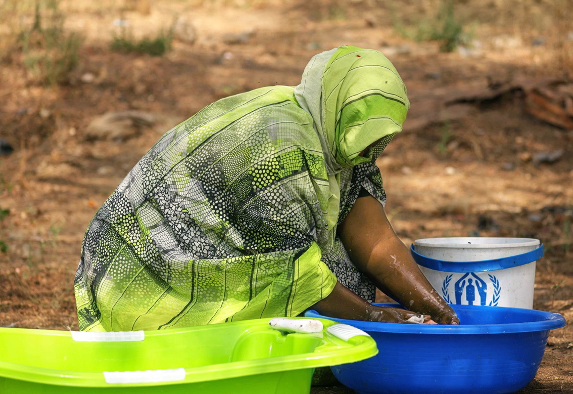 Fatima đang giặt giũ bên ngoài khu trú ẩn gần biên giới Ethiopia - ẢNH: UNHCR/TIKSA NEGERI