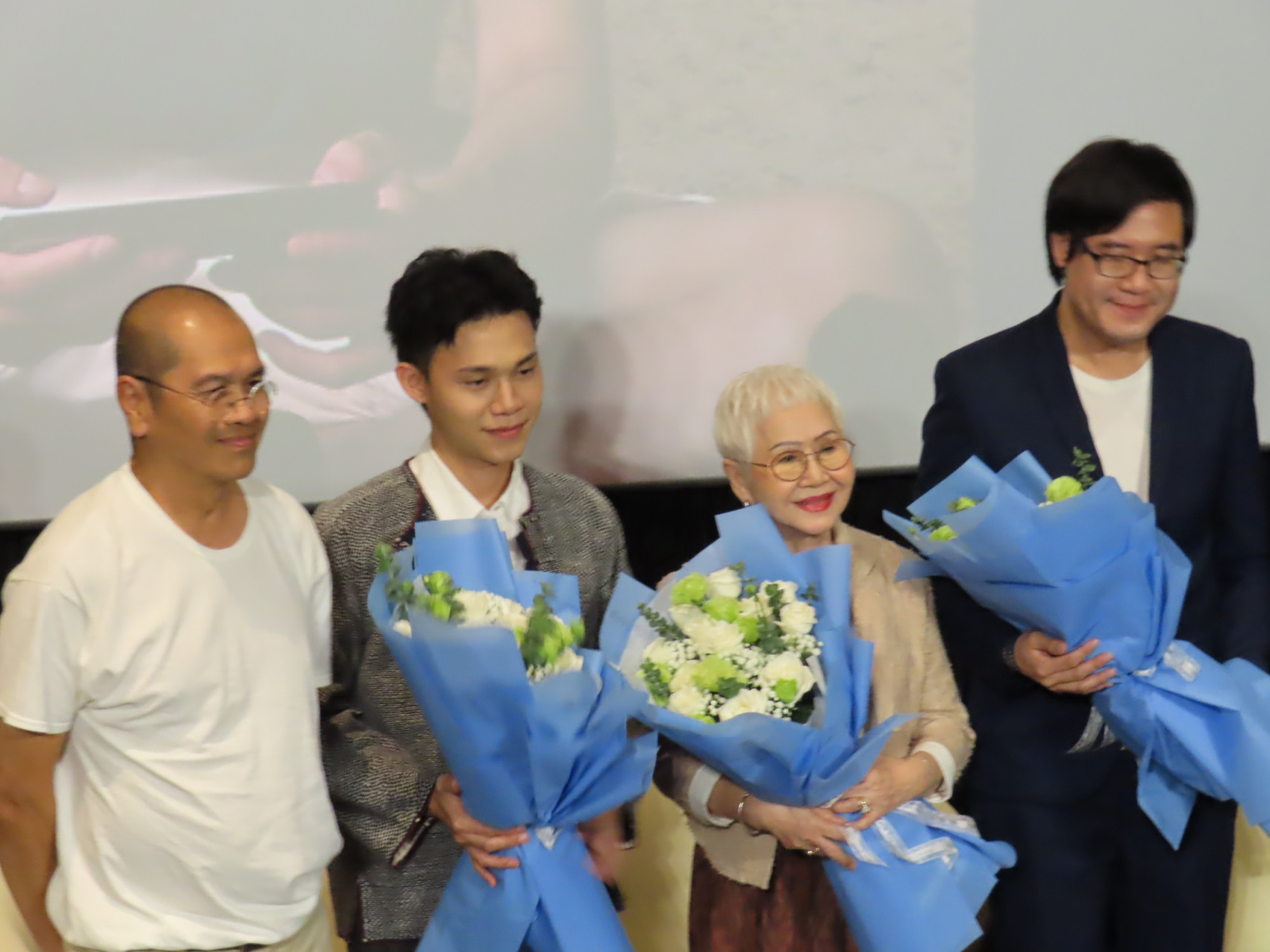 Nhà sản xuất, đạo diễn, diễn viên và biên kịch phim Gia tài của ngoại (từ trái sang) nhận hoa chúc mừng của ban tổ chức 