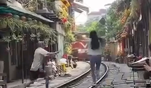 Khoảnh khắc cô gái lao ra giữa đường ray khi đoàn  tàu đang đến - Ảnh cắt từ clip