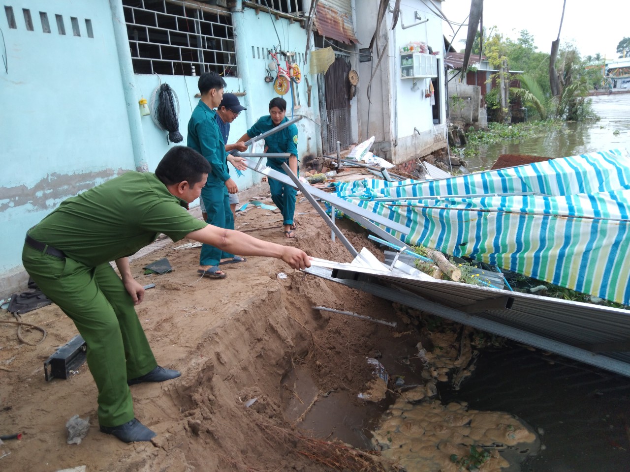 Lực lượng chức hỗ trợ giúp dân di dời tài sản ra khỏi khu vực sạt lở