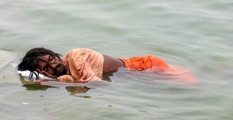 Một người đàn ông ngủ trên sông Hằng, vào một ngày hè nóng nực ở Varanasi, ngày 18/6. ẢNH: AFP