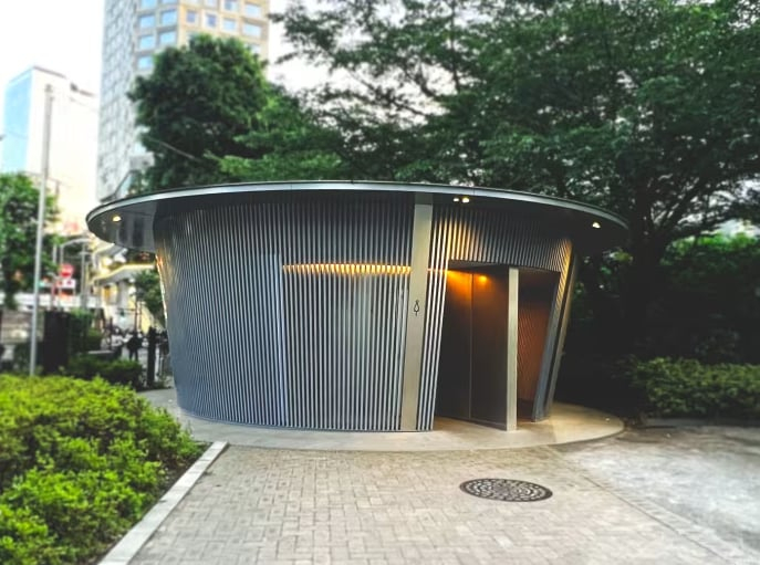 Nhà vệ sinh công viên Jingu-Dori. Nhà vệ sinh này có hình tròn với tường làm bằng kim loại thẳng đứng để thông gió. Mái nhà được mở rộng ra như tán cây để khách trú mưa. Ảnh: CNA/Jasber Loh