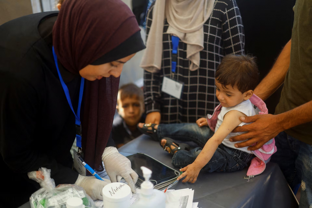 Một cậu bé Palestine suy dinh dưỡng được điều trị tại bệnh viện dã chiến của Quân đoàn Y tế Quốc tế ở Deir Al-Balah, phía nam Dải Gaza - Ảnh: REUTERS/Mohammed Salem