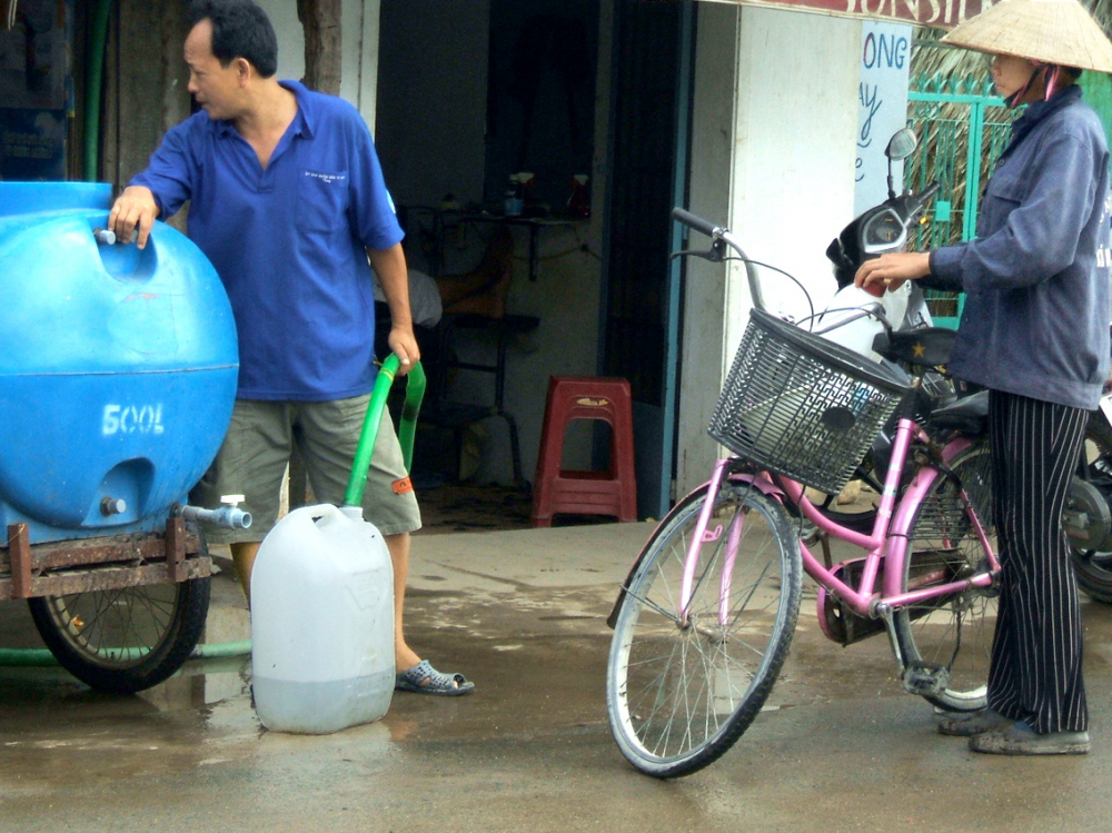 Người dân mua nước sạch trên đường Lê Văn Lương (ấp 3, xã Phước Kiển, huyện Nhà Bè) ngày 14/2/2006 ẢNH: HƯƠNG HUYỀN