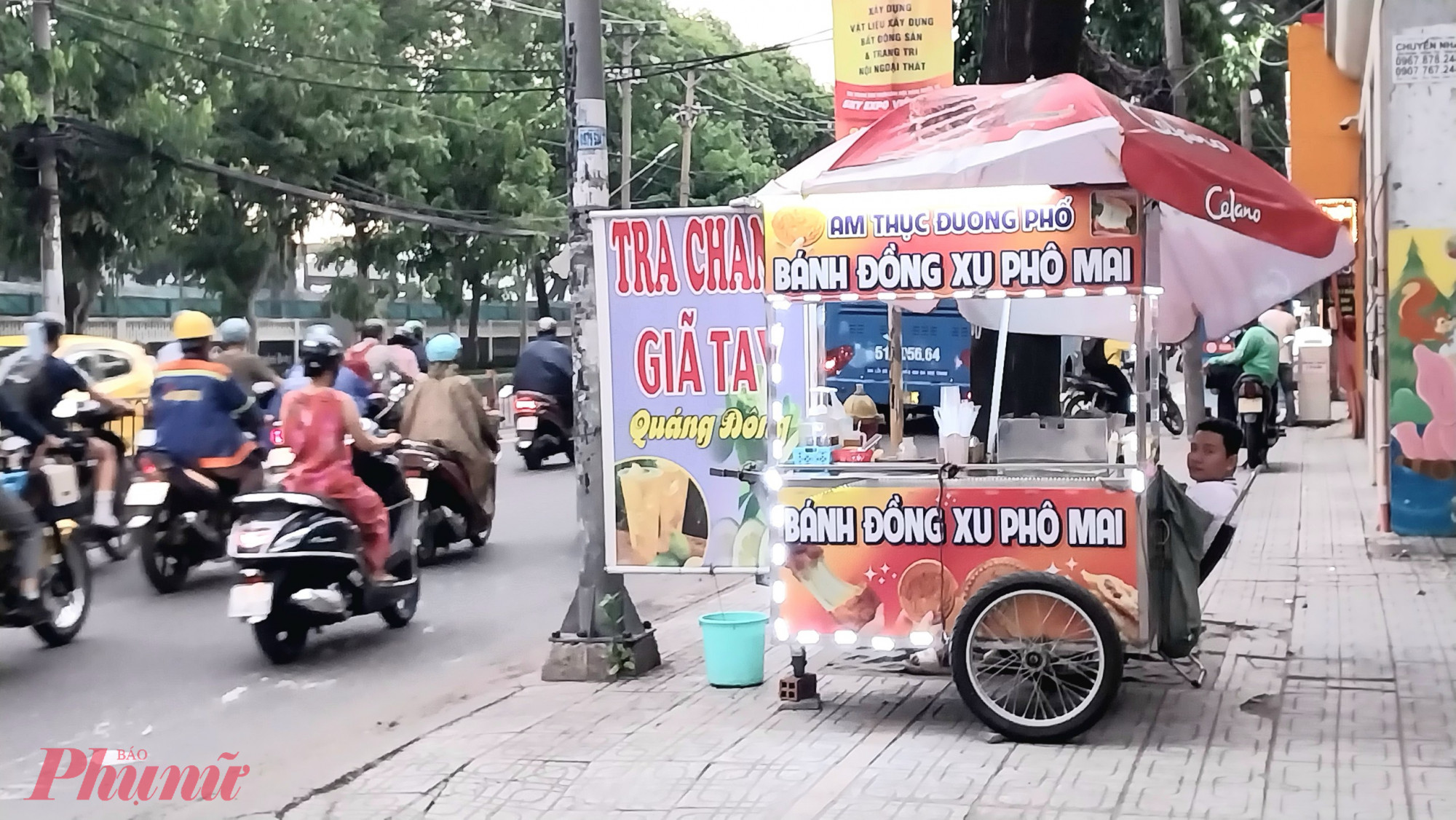 ó nguồn gốc từ Hàn Quốc, món bánh đồng xu phô mai kéo sợi (còn gọi là bánh 10 Won) trở thành món ăn siêu hot trên mạng xã hội. Thời điểm tháng 9/2023, xe đẩy bán loại bánh này xuất hiện dày đặt trên các tuyến đường trên địa bàn TPHCM. Điểm bán nào cũng có người xếp hàng dài từ 30 phút đến 1 tiếng mới có thể mua loại bánh này do quy trình làm một cái bánh phải trải qua nhiều công đoạn. Tuy nhiên, có những thời điểm, một điểm bán sẽ bán được từ 1.000 - 2.000 cái bánh/ngày, với mức giá 35.000 đồng/cái thì các điểm bán này thu lợi nhuận khủng. Song hiện tại, điểm bán nào cũng rơi vào tính trạng ế ẩm. Trong ảnh là một điểm bán trên đường Quang Trung (quận 12, TPHCM), do ế khách nên chủ điểm bán phải ngồi bấm điện thoại cho giết thời gian. Trước đây, mỗi ngày tôi bán được 200 cái bánh, nay chỉ bán được từ 10 - 20 cái bánh. Trước đây, đoạn đường Quang Trung này có tới 4-5 điểm bán bánh đồng xu thì nay chỉ còn một mình tôi bán - chủ điểm bán này chia sẻ