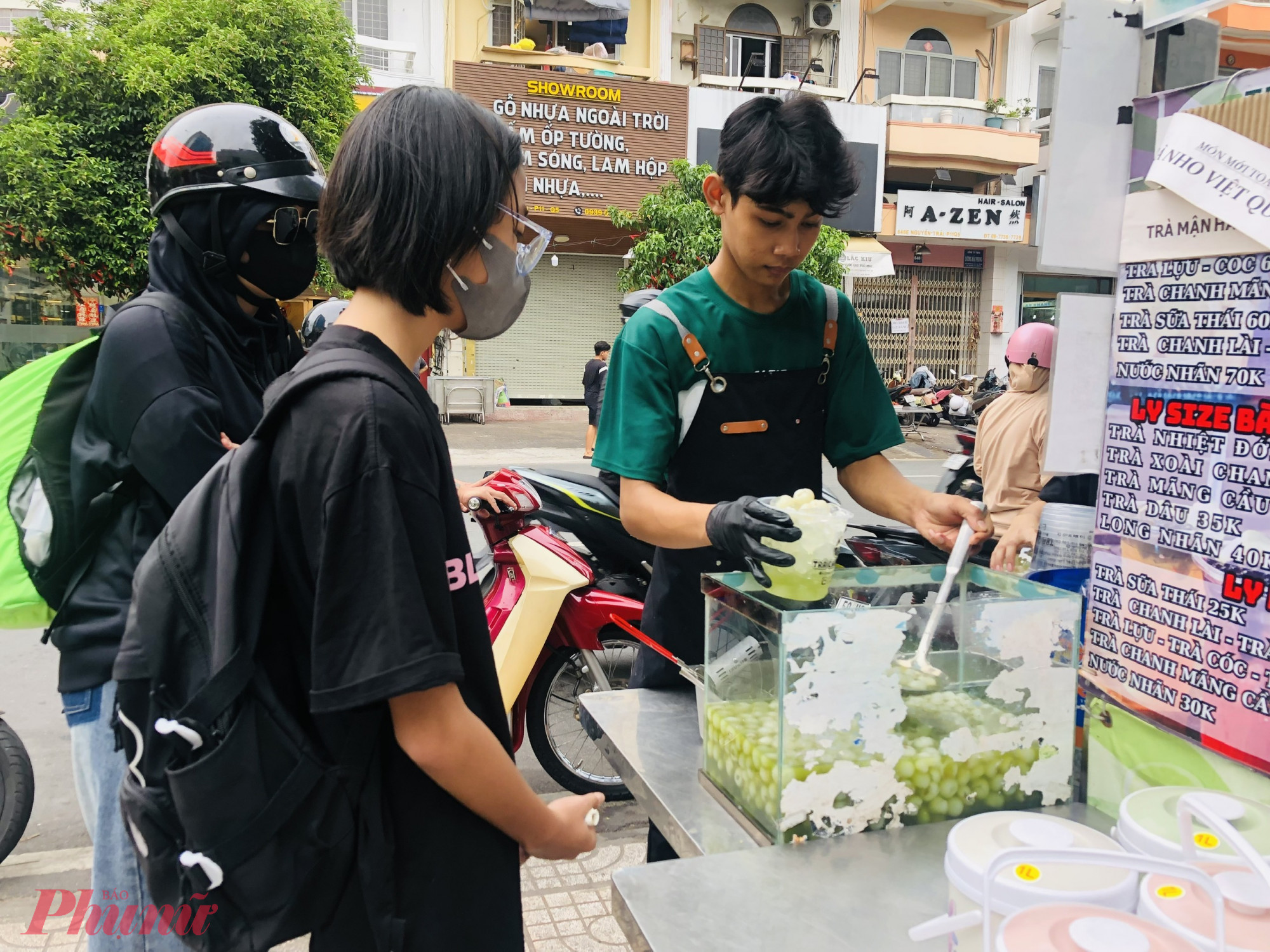 Trong số khách đang chờ mua nước chiều ngày 26/6, chúng tôi thấy đa phần khách đều chọn nước nhãn Thái Lan. Ngoài dạng ly với giá 30.000 - 35.000 đồng/ly, điểm bán này còn đựng thức uống trong xô nhựa có dung tích 1 - 1,3 lít, có giá từ 60.000 - 70.000 đồng/xô. Nước uống đựng xô siêu to siêu khổng lồ này đang là xu hướng, hầu như điểm bán nước lề đường nào có, nếu không bắt kịp xu hướng thì khách sẽ không ghé mua - nhân viên tại đây nói.