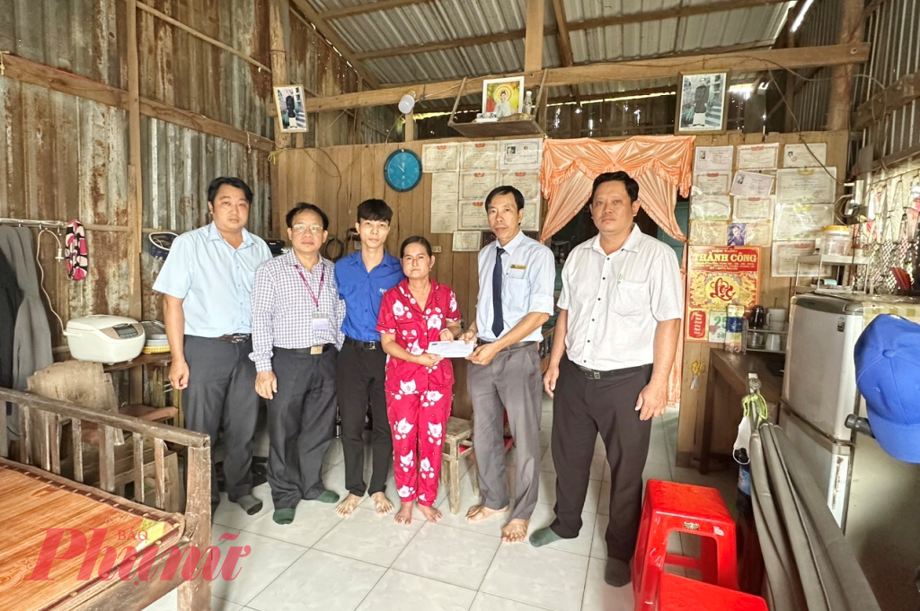 Đại diện Trường Đại học Cửu Long trao 17 triệu đồng hỗ trợ ban đầu giúp An - Ảnh: Nguyễn Văn Dô