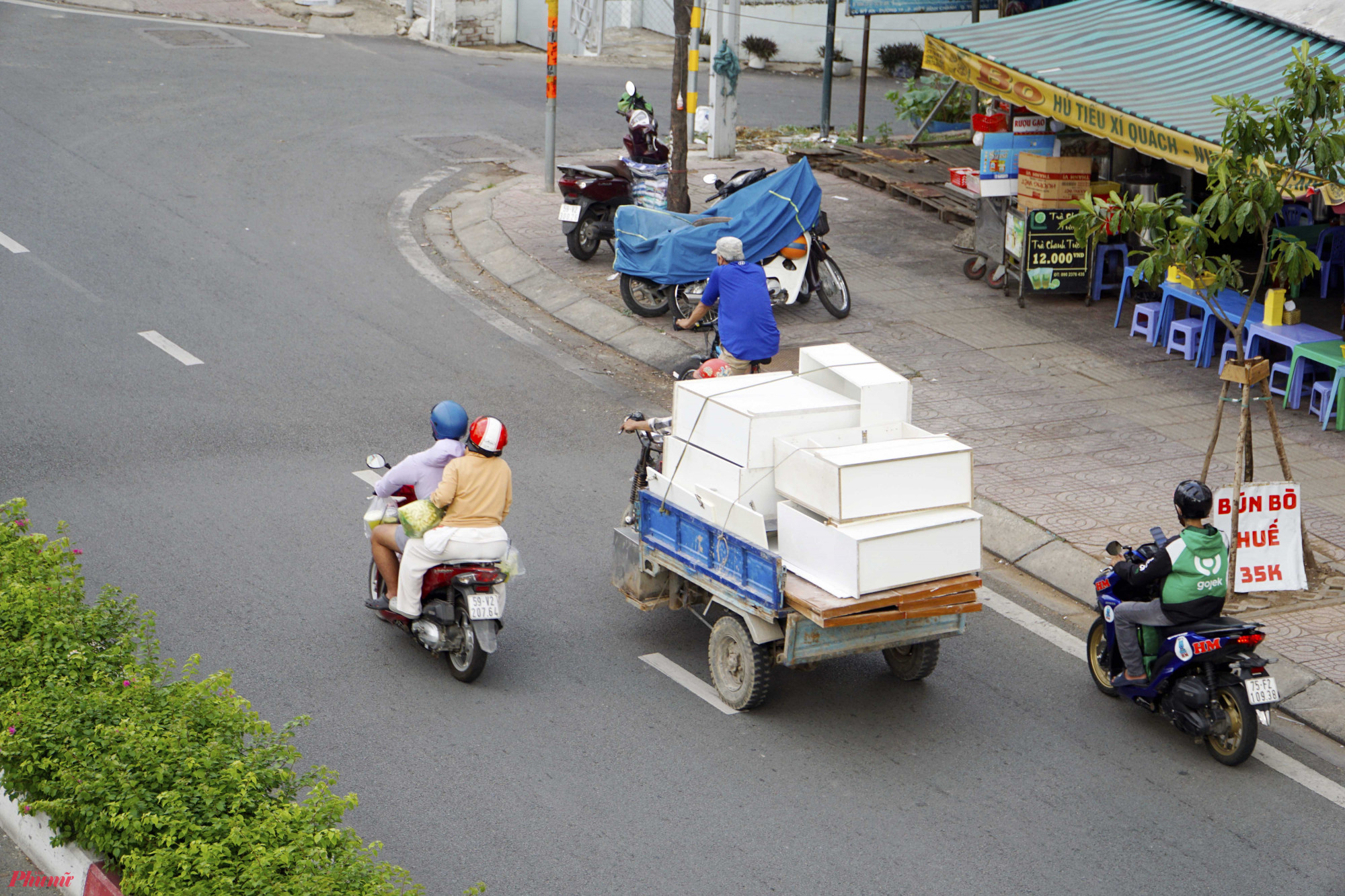 Một chiếc xe 3 bánh chở hàng cồng kềnh chạy trên đường Phạm Văn Đồng, phường Hiệp Bình Chánh, TP Thủ Đức 