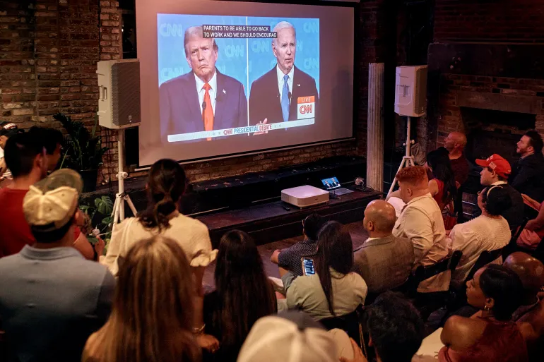 Những người ủng hộ ông Trump lắng nghe trong bữa tiệc theo dõi cuộc tranh luận tổng thống của đảng Cộng hòa vào ngày 27/6 - Ảnh: Andres Kudacki / AP
