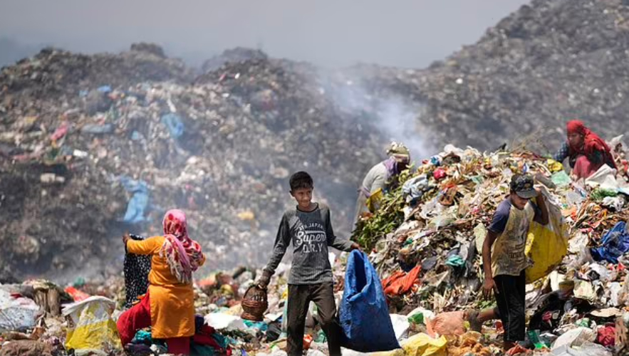 Người nhặt rác Rajdin, 17 tuổi, đang tìm kiếm vật liệu tái chế trong đợt nắng nóng tại một bãi rác ở ngoại ô Jammu, Ấn Độ, thứ Tư, ngày 19 tháng 6 năm 2024. Có tới 4 triệu người ở Ấn Độ kiếm sống bằng cách lục tung các bãi rác để tìm bất cứ thứ gì họ có thể bán được. (Ảnh AP/Channi Anand)