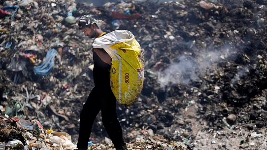 Aamir Shekh đang tìm kiếm vật liệu tái chế tại một bãi rác trong đợt nắng nóng ở ngoại ô Jammu, Ấn Độ, 