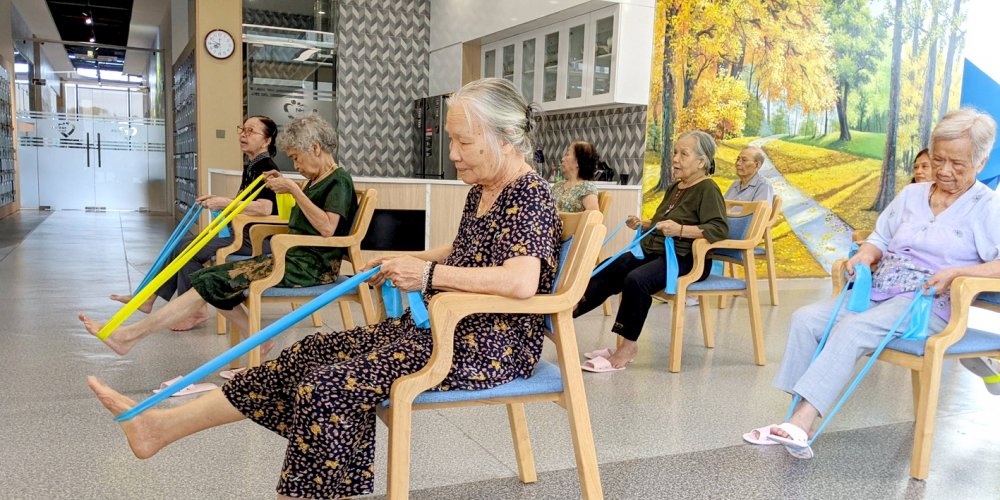 Các cụ tập luyện bài thể dục với dây thun tại trung tâm dưỡng lão Nhân Ái - ẢNH: M.T.