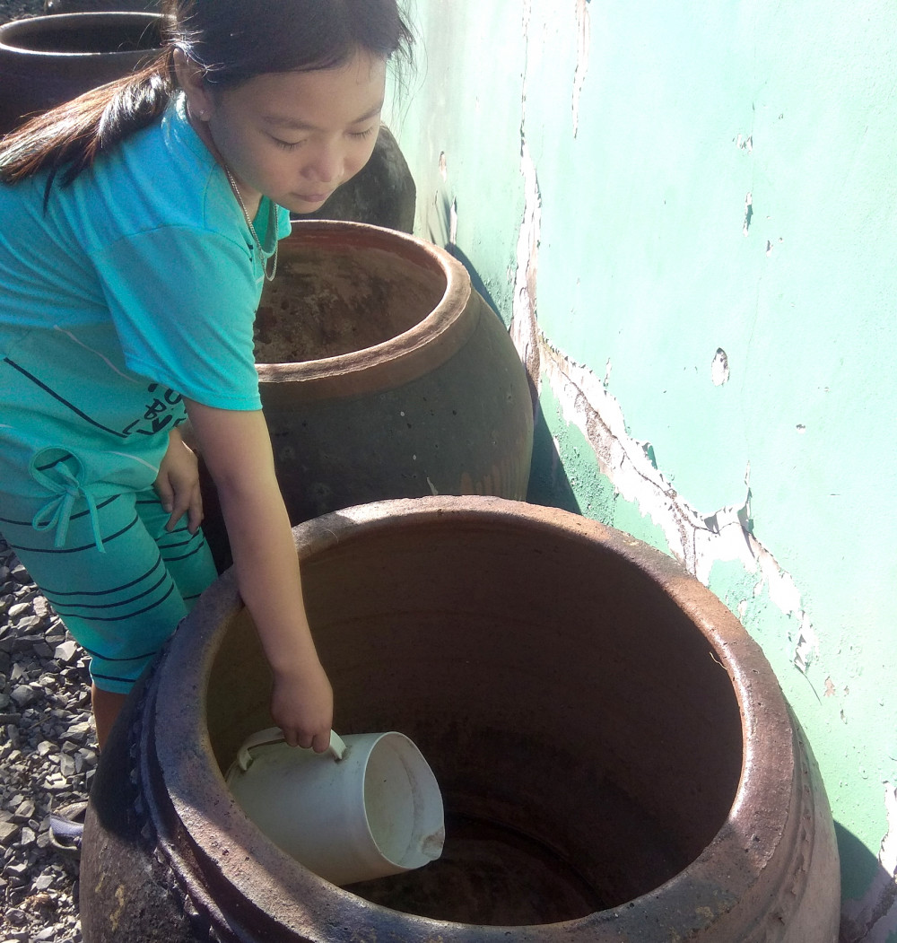 Hiện nay, nhiều người dân ở vùng ngoại thành TPHCM vẫn còn thói quen tích trữ nước mưa trong lu, bồn để tiết kiệm nước - ẢNH: S.V