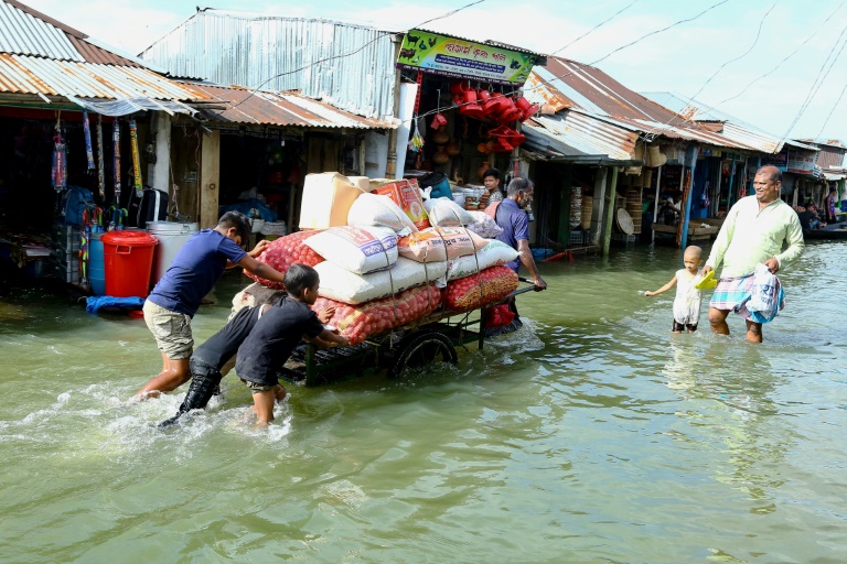 Mọi người đẩy xe kéo chở hàng cứu trợ qua lũ lụt tại Fenchuganj ở Sylhet vào ngày 3/7/2024 - Ảnh: AFP