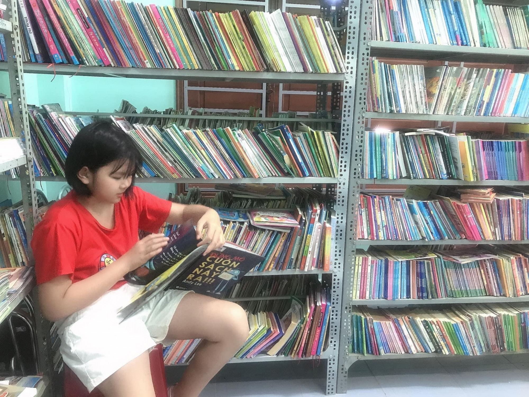 Con đọc sách trong thư viện của mình