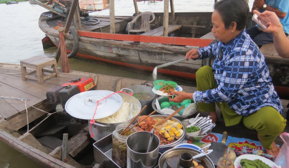 Một ghe bán cơm tấm trên chợ nổi Long Xuyên. Do khu vực này có nhiều ghe thương hồ neo đậu lâu ngày nên các ghe bán đồ ăn khá phong phú, đa dạng.