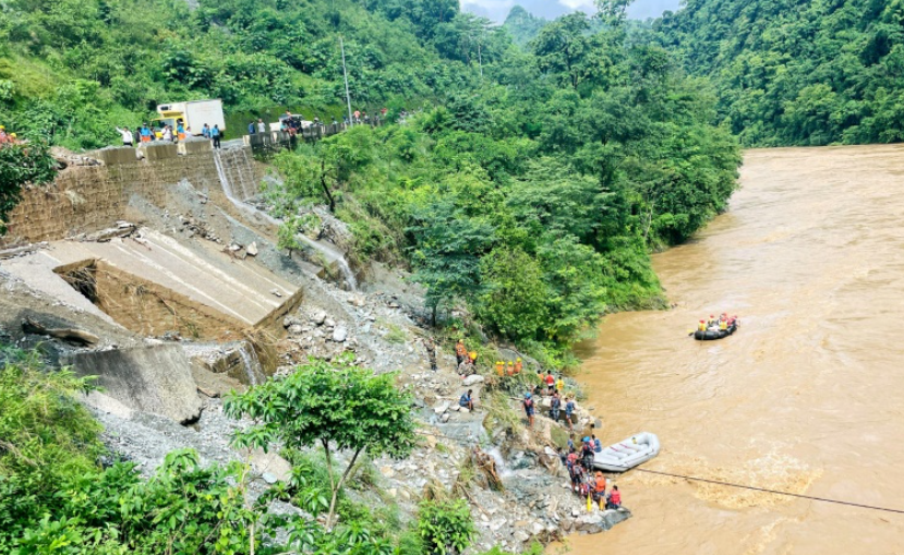 Lực lượng cứu hộ tìm kiếm những người sống sót ở sông Trishuli tại Simaltar sau khi một trận lở đất do mưa lớn gây ra đã cuốn trôi hai chiếc xe buýt khỏi đường cao tốc  Ảnh: AFP