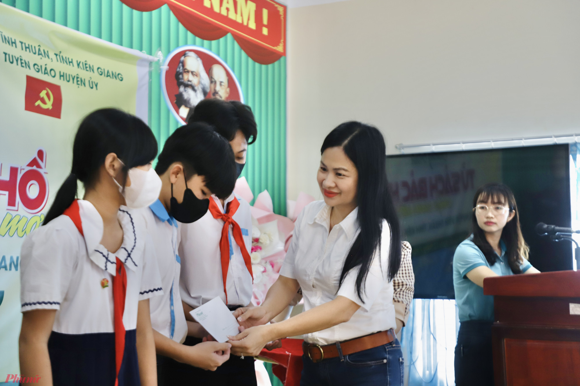 Bà Phạm Thị Vân Anh - Phó tổng biên tập Báo Phụ Nữ TPHCM trao học bổng cho các em học sinh Trường TH - THPT Vĩnh Bình Bắc.