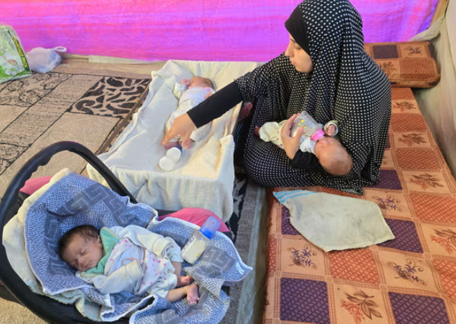 Yasmeen Khuwaiter trong lều của cô với ba đứa con sinh ba – cô đã thụ thai thông qua phương pháp điều trị IVF sau chín năm cố gắng để có con. Ảnh: Care