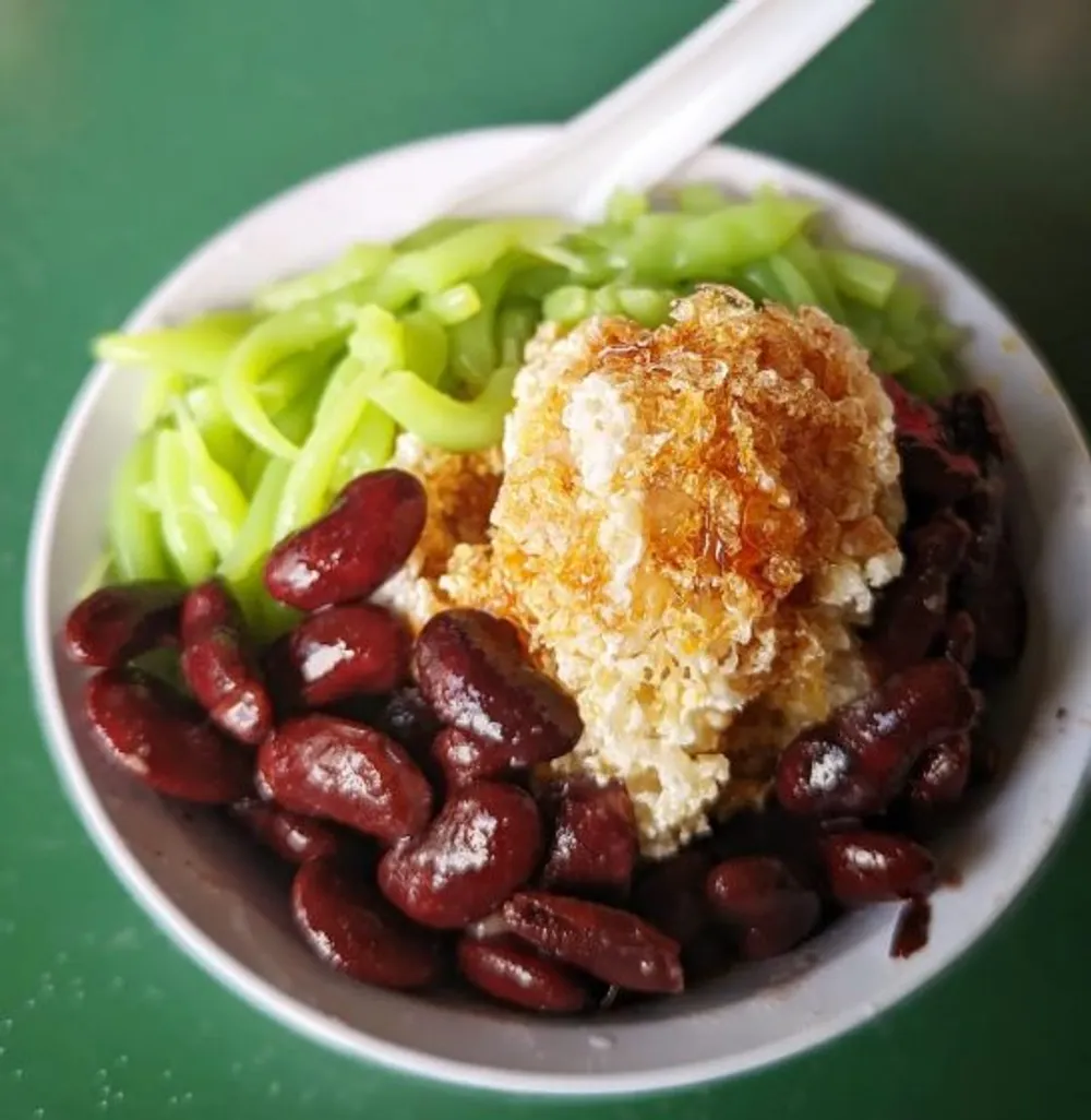 Chendol – hay cendol theo cách viết ban đầu – có thể được coi là người anh em họ khiêm tốn của món bingsu Hàn Quốc thời thượng ở Đông Nam Á , nhưng thay vì một núi đá bào phủ sôcôla và trái cây, món tráng miệng không chứa gluten này có hỗn hợp thạch bột gạo xanh, nước cốt dừa và gula melaka . Trong khi nhiều người cho rằng món chendol ngon nhất đến từ Malaysia, chúng ta biết chắc rằng Singapore có những phiên bản có thể sánh ngang với người hàng xóm giáp ranh của chúng ta.  