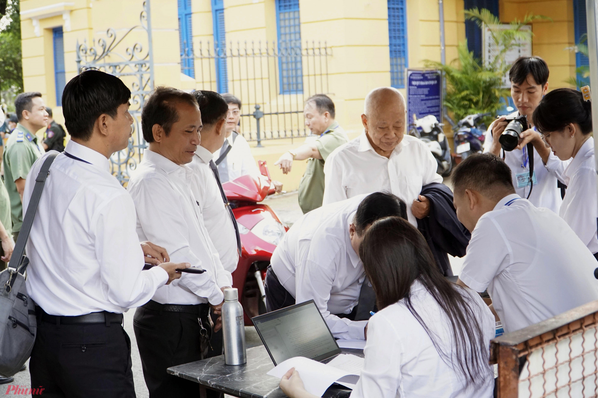 Các luật sư làm giấy đăng ký thông tin trước khi vào toà.