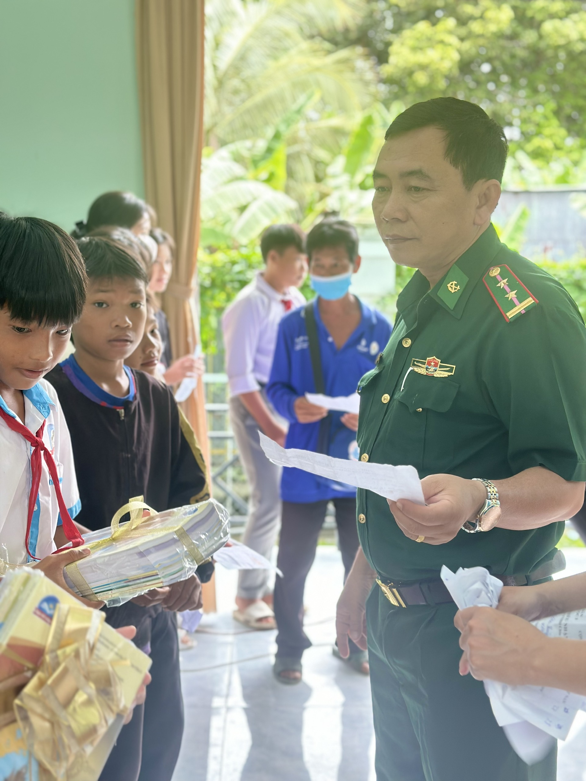 Ông Trần Văn Ruộng - Đội phó Đội Vận động quần chúng đồn biên phòng cửa khẩu quốc tế Thường Phước (cột mốc 240) trao quà cho học sinh nghèo. Ảnh: T.L.T.