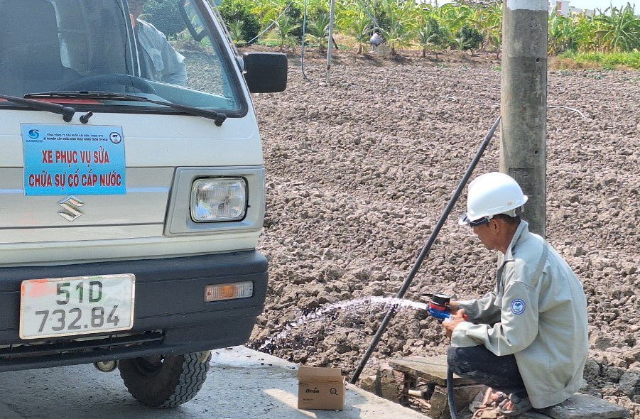 Công nhân của Xí nghiệp cấp nước sinh hoạt nông thôn (thuộc SAWACO) đang lắp đồng hồ nước cho người dân ở huyện Bình Chánh - ẢNH: ĐINH QUỐC PHONG.