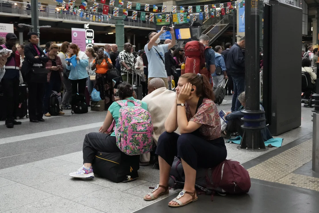 Một hành khách đang chờ tại nhà ga xe lửa Gare du Nord ở Paris vào ngày 26/7 - Ảnh: Mark Baker/AP