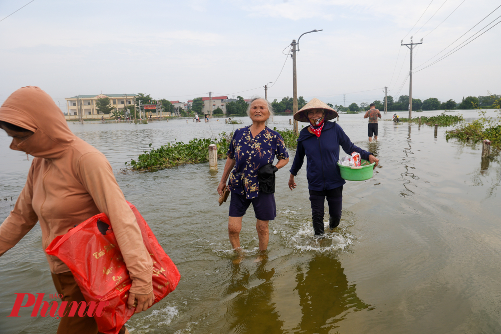 Ghi nhận của phóng viên, khoảng 1 tuần nay, con đường chính dẫn vào xóm Bến Vôi và đồng ruộng chìm ngập trong biển nước. người dân phải men theo hàng cột điện và cột mốc đường ven bờ để di chuyển được an toàn. 