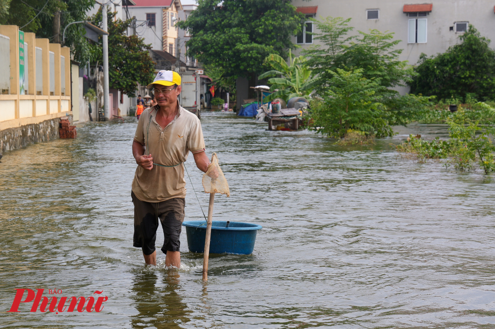 Người dân di chuyển trong thôn xóm ra cần dùng nhiều vật dụng để dò đường đảm bảo đi lại an toàn.