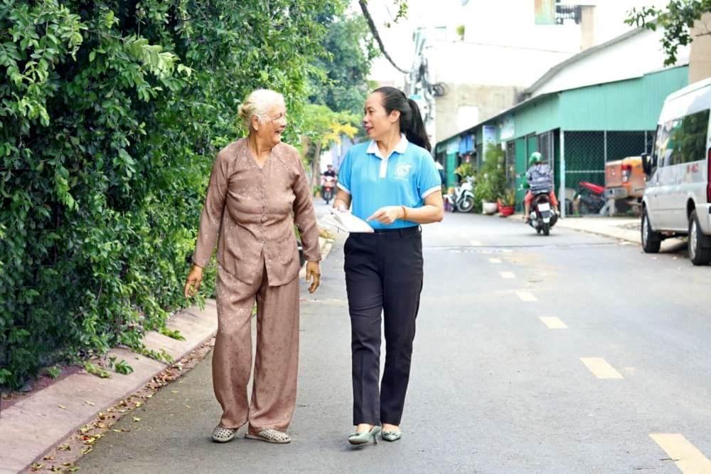 Bà Thạch Thị Song đi trên con hẻm 175, đường 2, phường Tăng Nhơn Phú  đã được mở rộng, tráng nhựa phẳng phiu - ẢNH: MẪN NHI