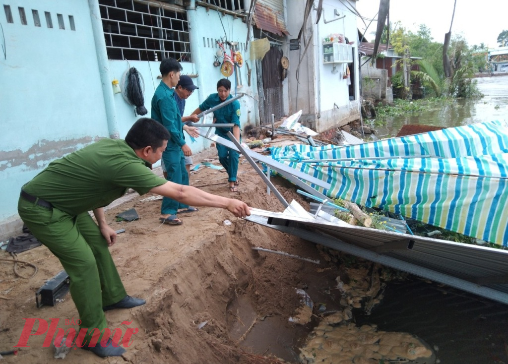 Lực lượng chức năng tỉnh Vĩnh Long hỗ trợ người dân di dời tài sản ra khỏi khu vực sạt lở - Ảnh: B.D.