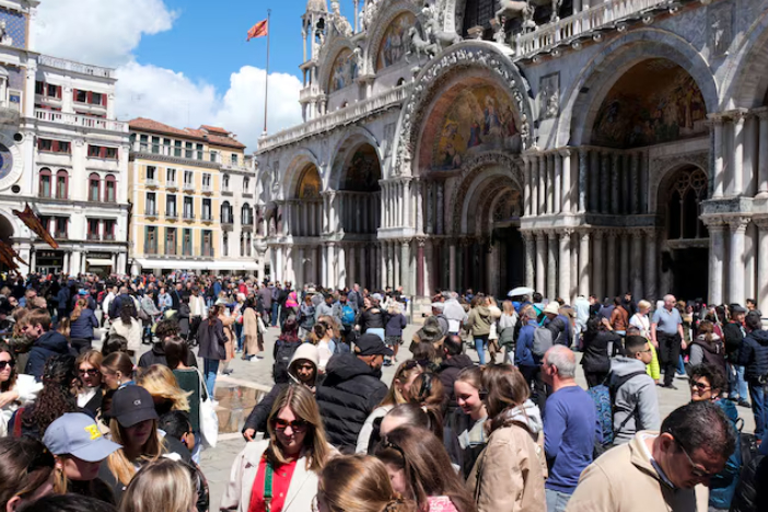 Khách du lịch đi bộ tại Quảng trường St Mark vào ngày thành phố Venice giới thiệu một khoản phí mới dành cho những người đi lại trong ngày trong một động thái nhằm bảo tồn thành phố đầm phá thường đông đúc khách du lịch ở Venice, Ý, ngày 25 tháng 4 năm 2024. REUTERS/Manuel Silvestri/Quyền cấp phép mua ảnh