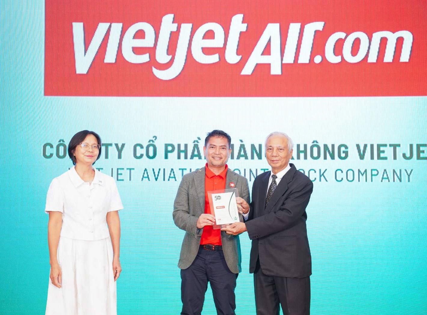 Ông Nguyễn An Di - Giám đốc Nhân sự Vietjet (đứng giữa) nhận giải thưởng tôn vinh Top 50 doanh nghiệp phát triển bền vững từ ban tổ chức - Ảnh: Vietjet