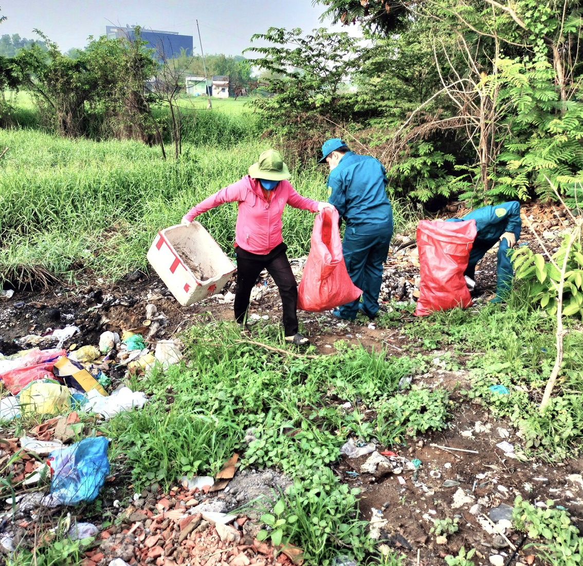 Chị Phương cùng dân quân thu dọn rác và trồng cây ở khu đất trống trên đường Nguyễn Văn Linh