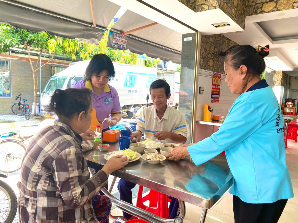 Những vị khách đầu tiên đến điểm “Cơm trưa yêu thương” phường Tân Hưng Thuận. 